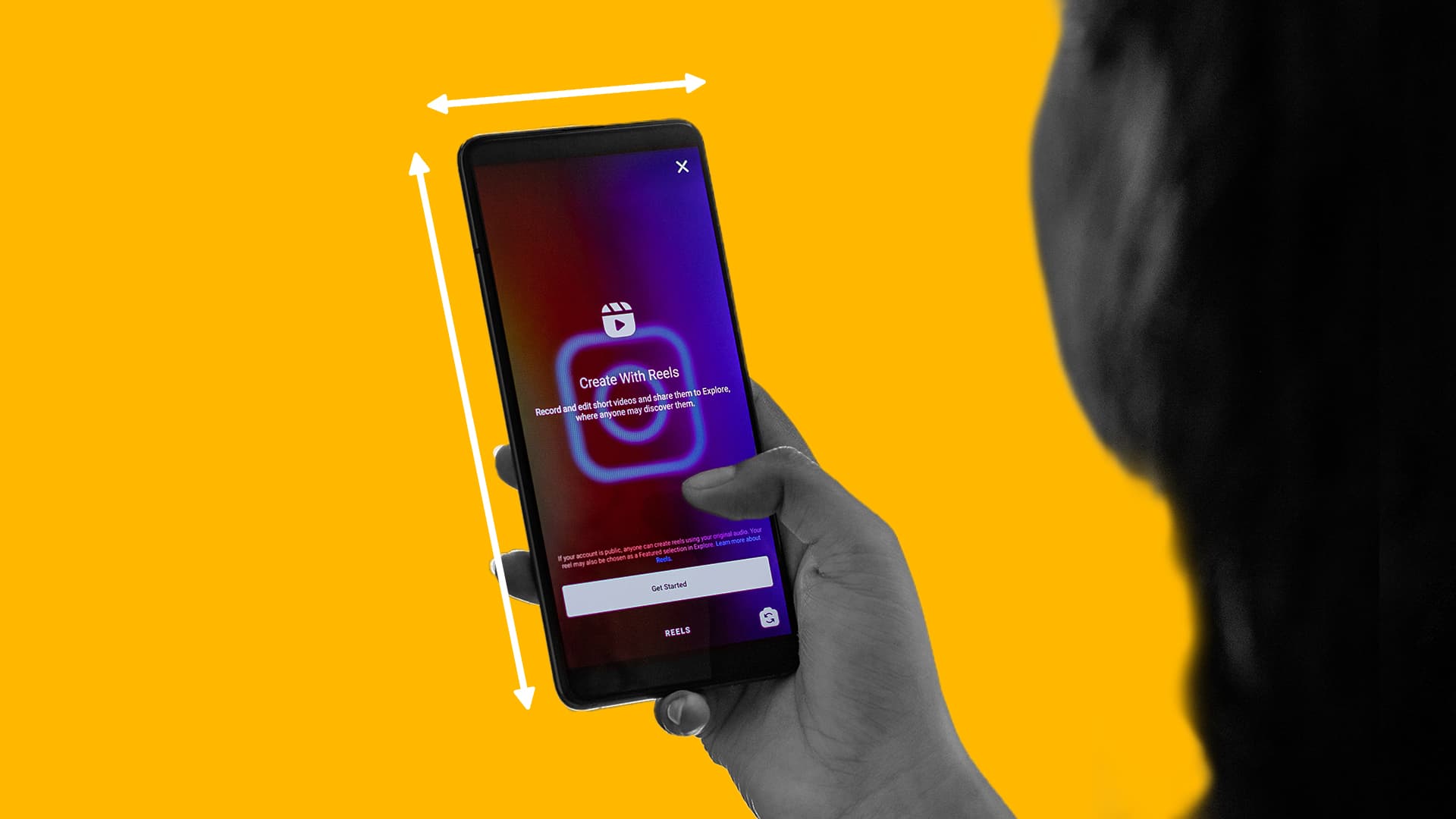 This photo is of someone holding a smart phone. The phone is opened on Instagram. Along the phone, there are lines to represent Instagram ad specs. This image represents Instagram's latest ad specs and placements guide.
